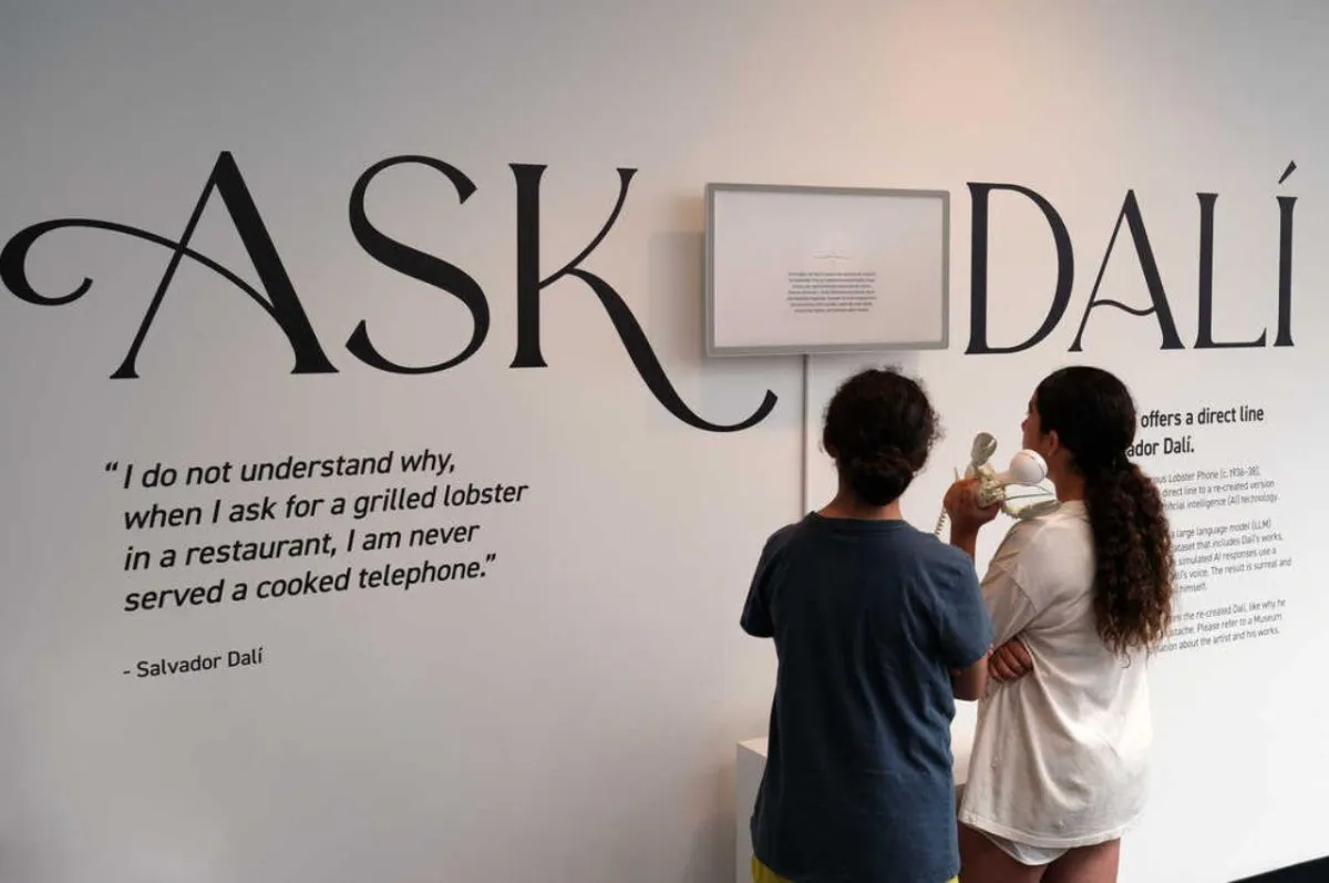 Deux visiteuses interrogent Salvador Dalí au téléphone homard dans l'installation Ask Dalí du Dalí Museum